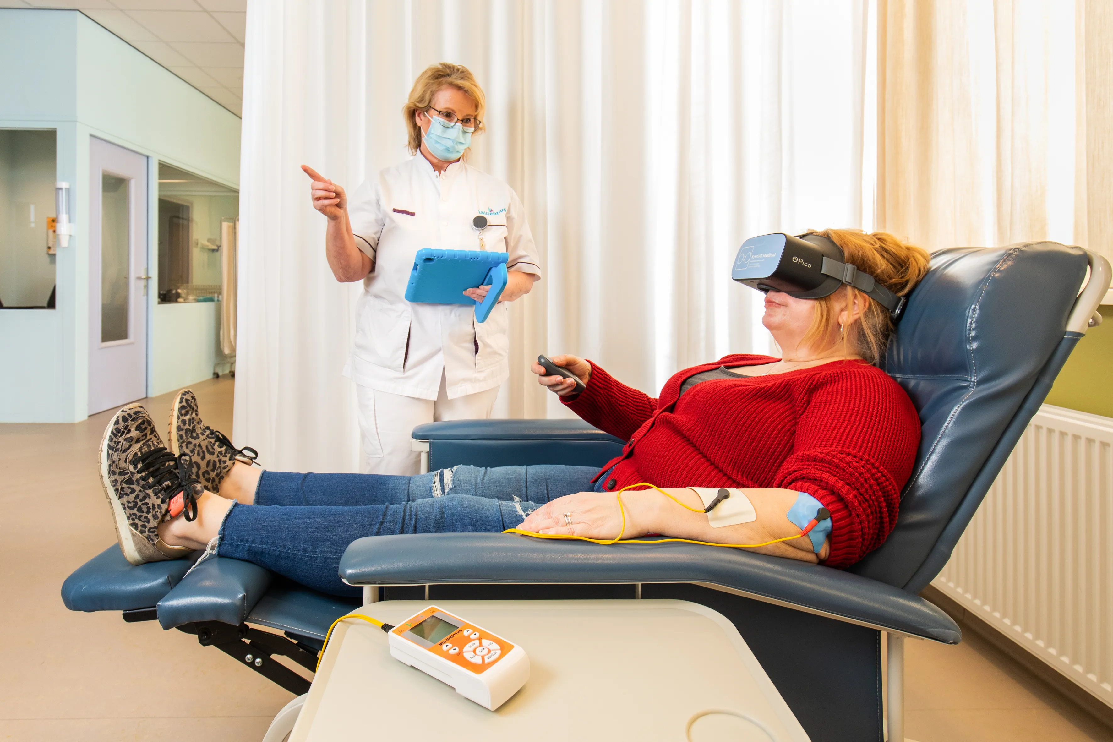 pijnverpleegkundige jose pijnenburg instrueert patient over de vr bril tijdens behandeling