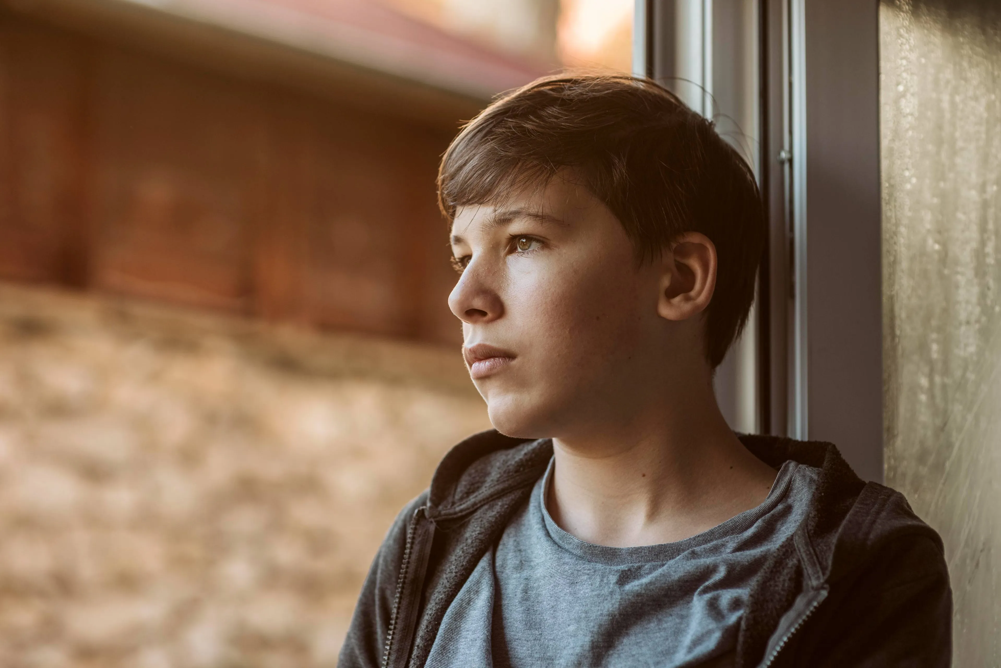 side-view-sad-boy-looking-outside