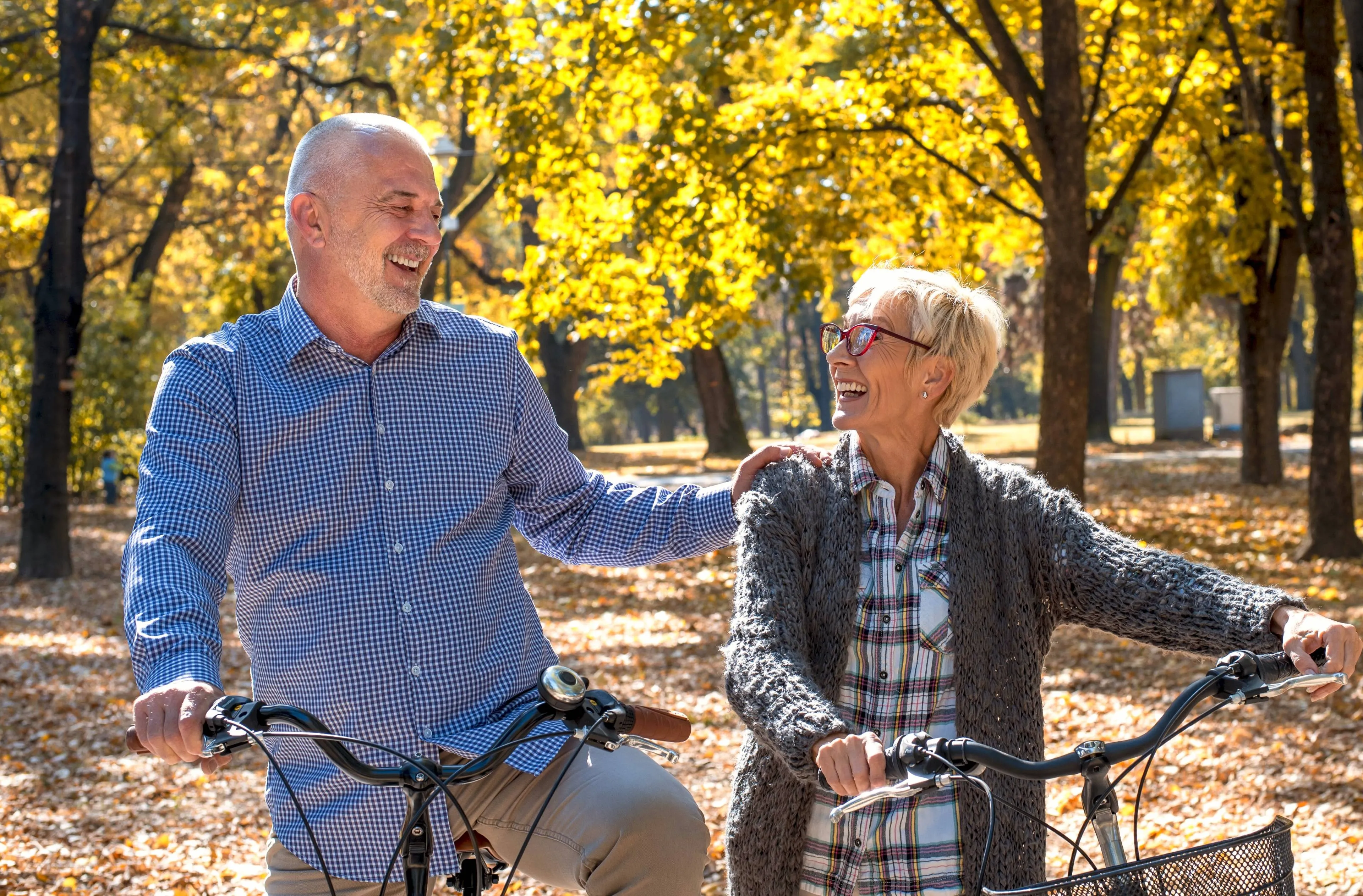 happy-elderly-couple-riding-bicycle-park-autumn