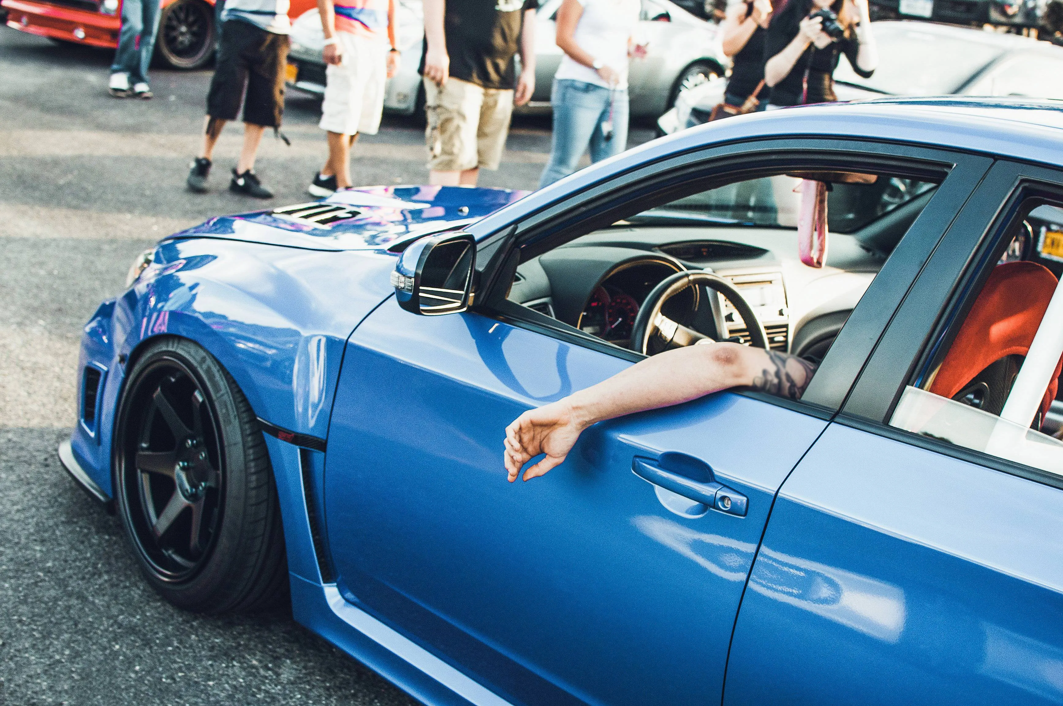 man-sits-blue-bmw-street