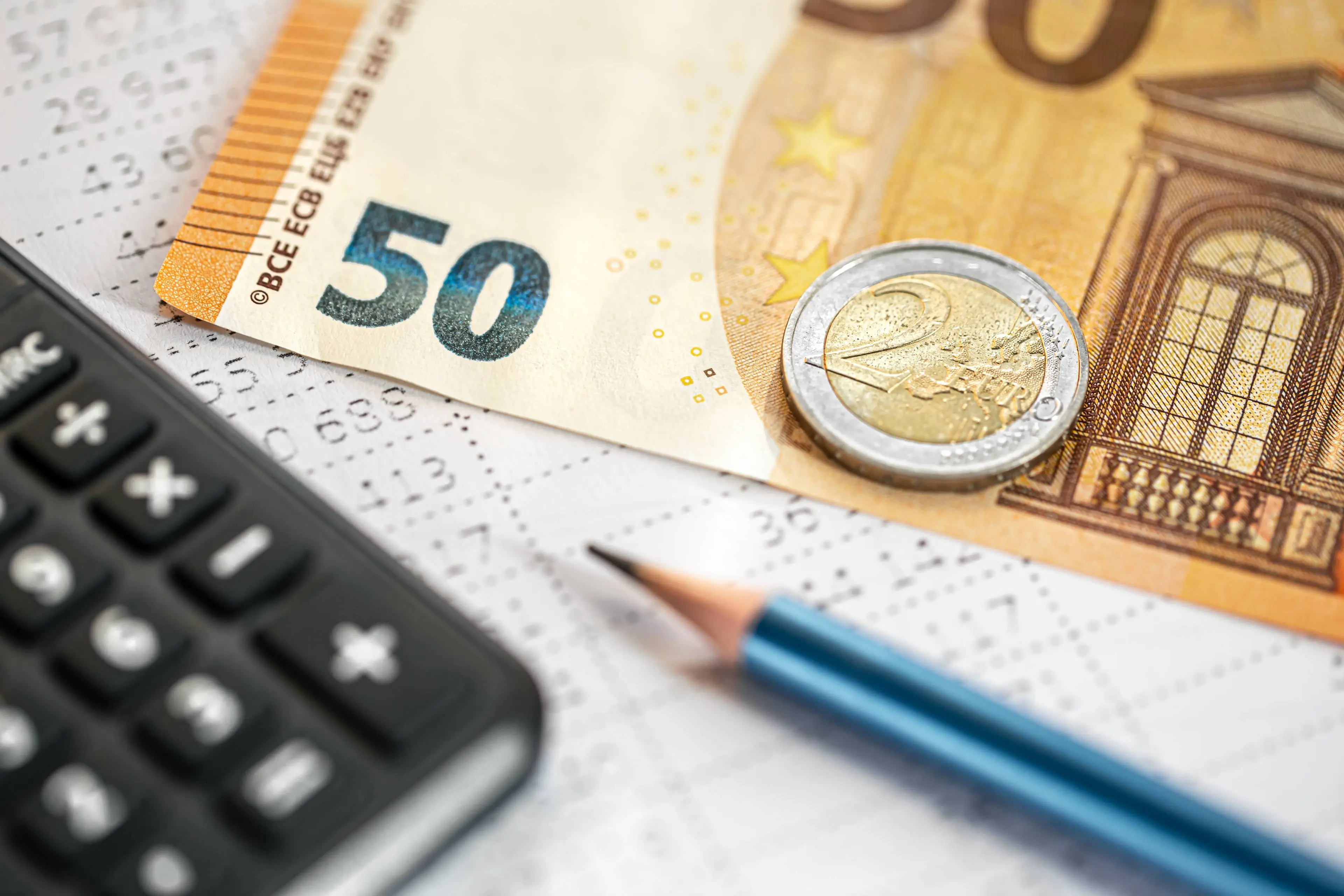 calculator-money-pencil-closeup-blurred-background