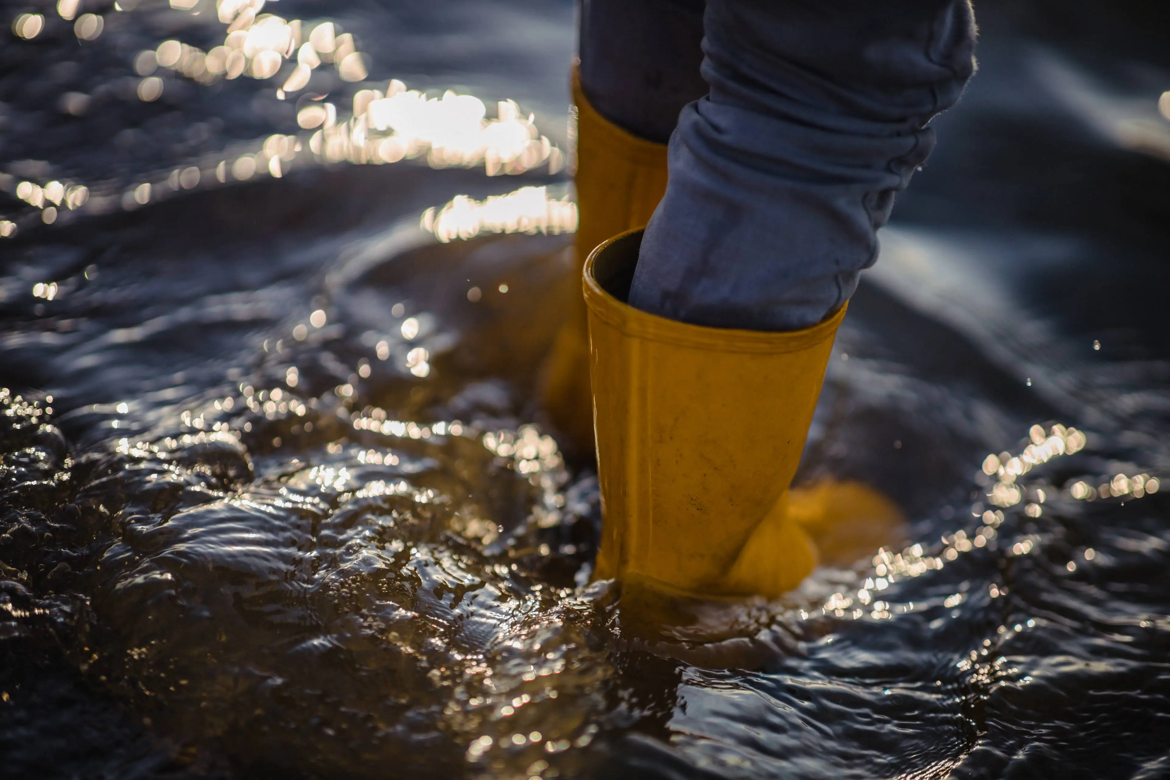 person-blue-denim-jeans-yellow-boots-standing-water