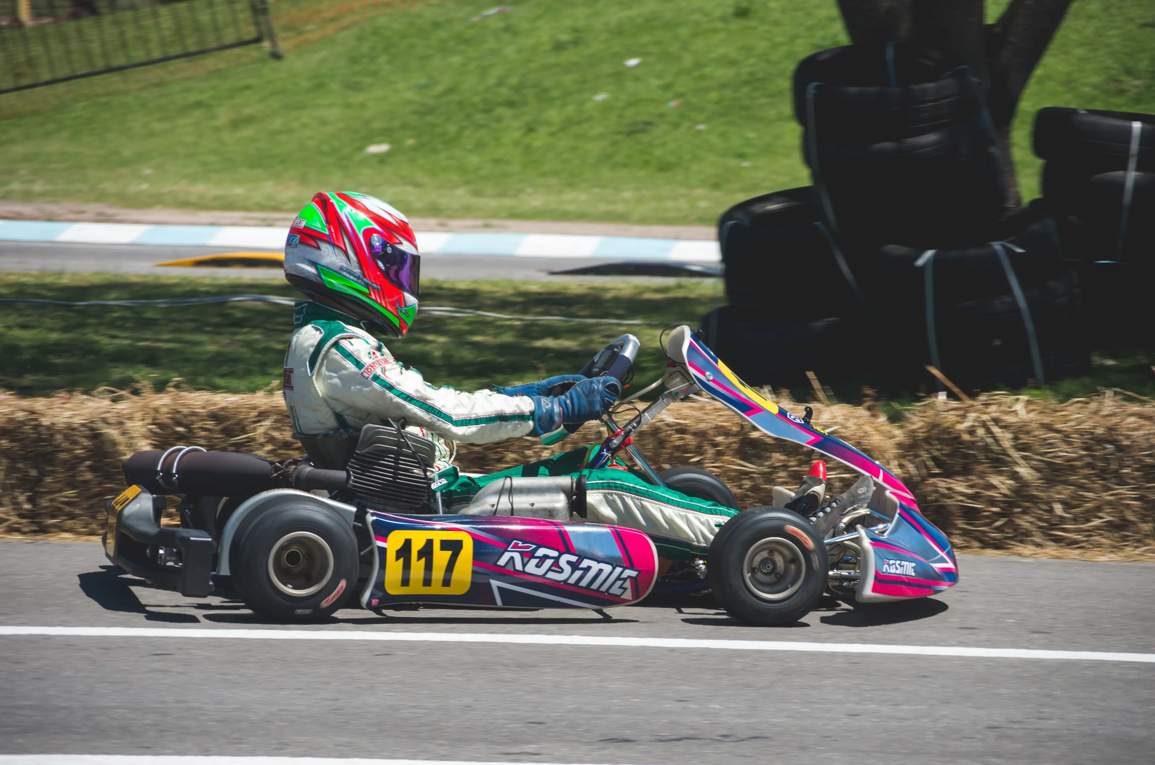 man in racing suit with helmet riding go kart 724704