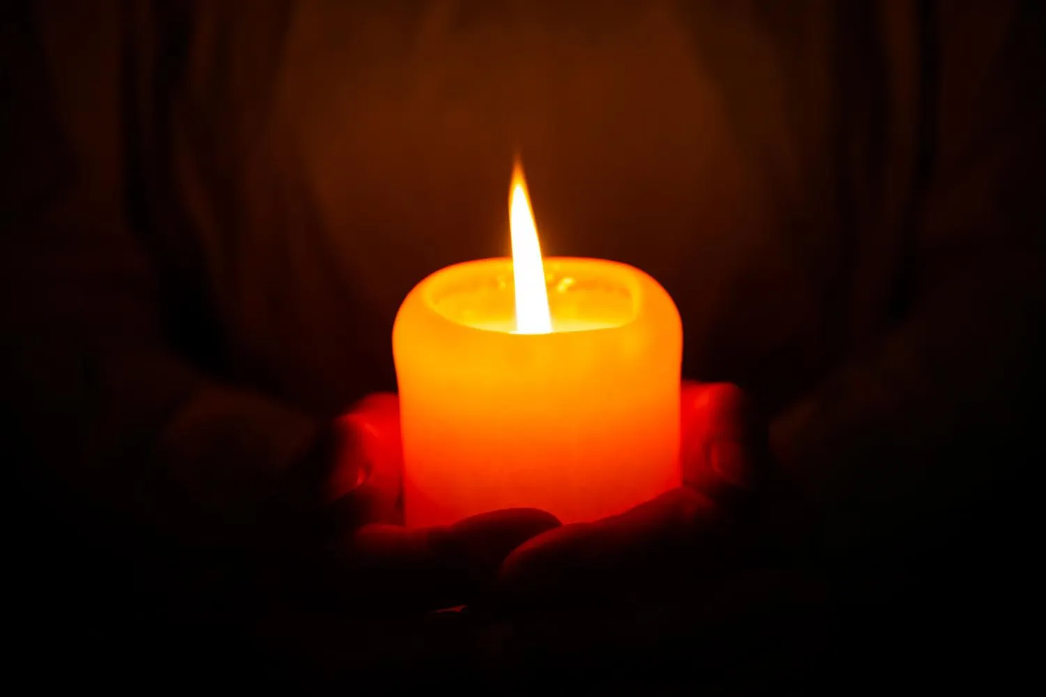 close up lit candle dark