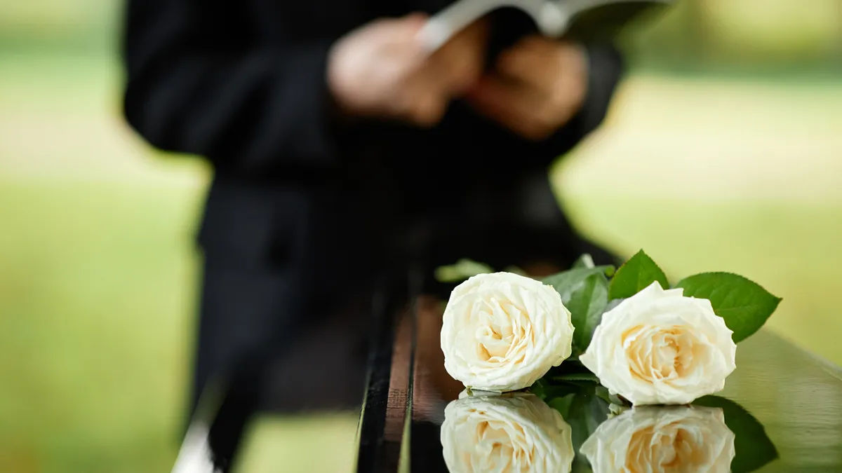 begrafenis kist twee witte rozen
