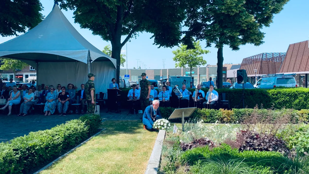 burgemeester verheijen legt bloemstuk met witte anjers bij het witte anjerperkje tijdens veteranendag in sittard