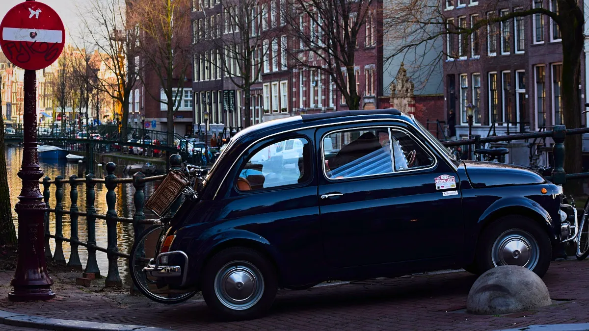 fiat 500 op voetpad brug over amsterdamse gracht