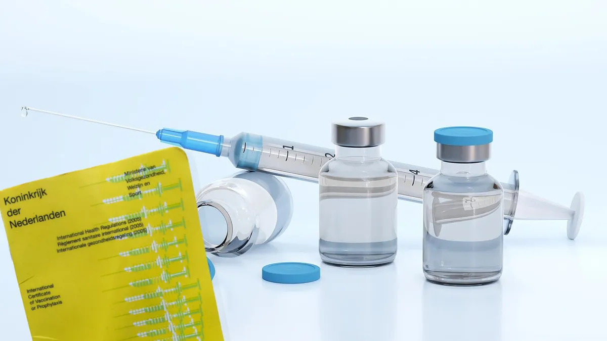gele boekje vaccin en spuit