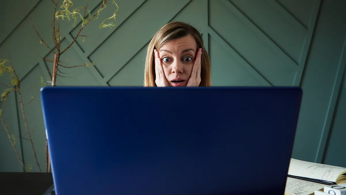 geschokte vrouw achter laptop