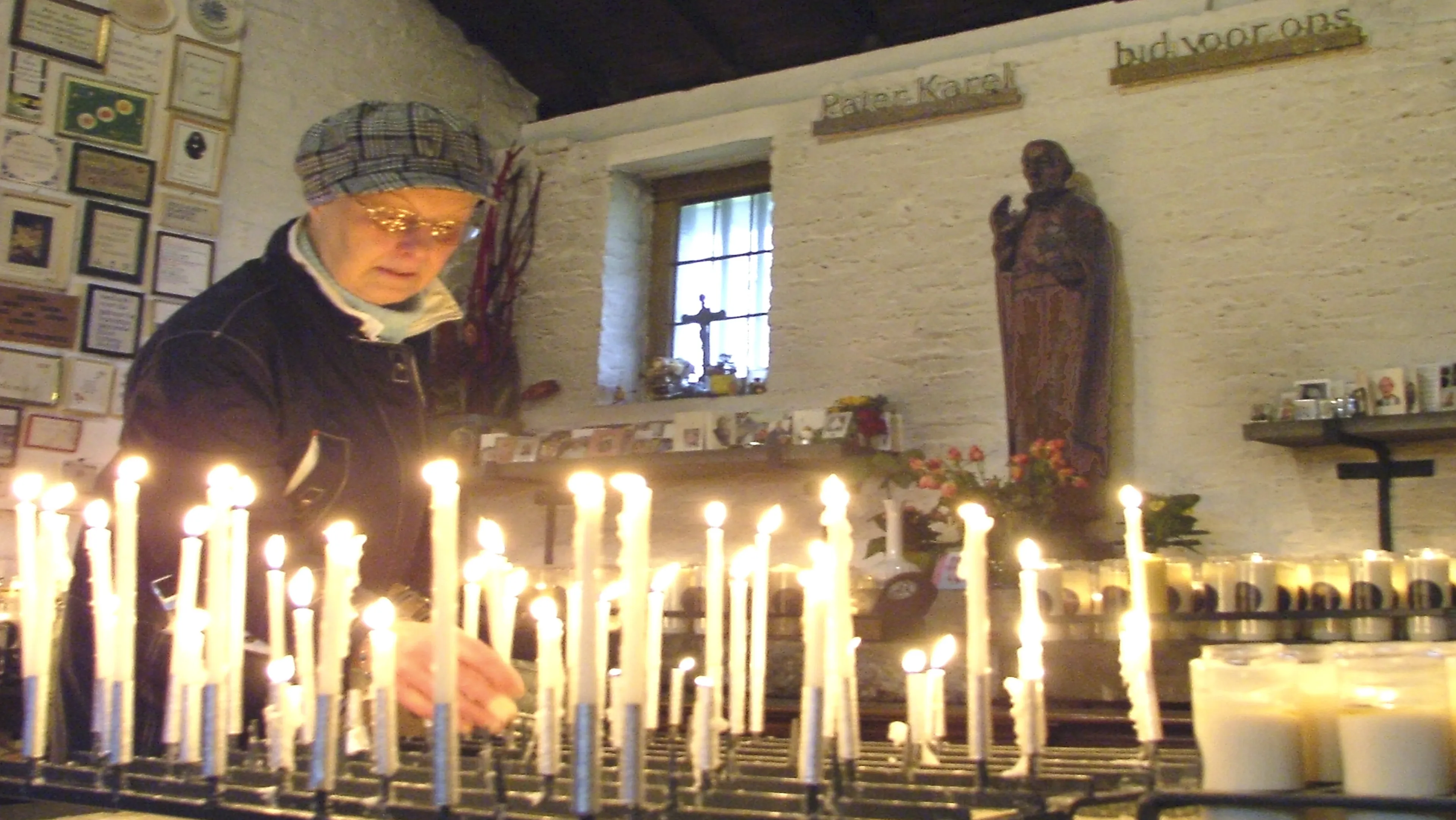 krwecnnalora9gyxoskj4gmmv paterkarel kapel vrouw steekt kaars aan