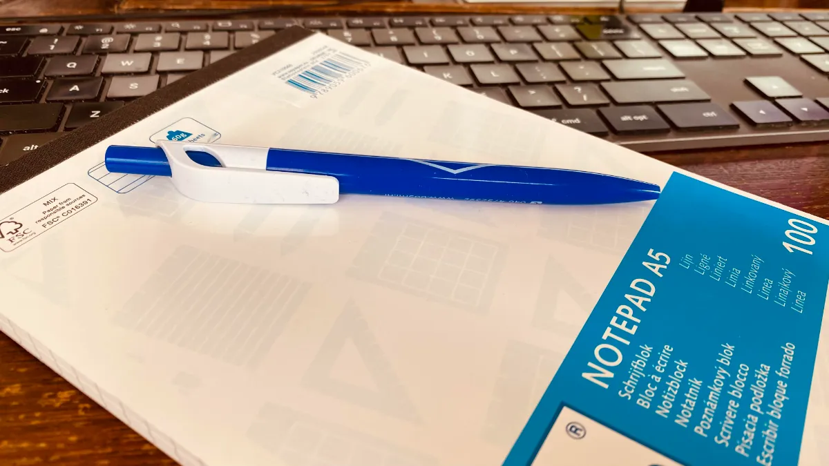 notitieblok met pen op toetsenbord