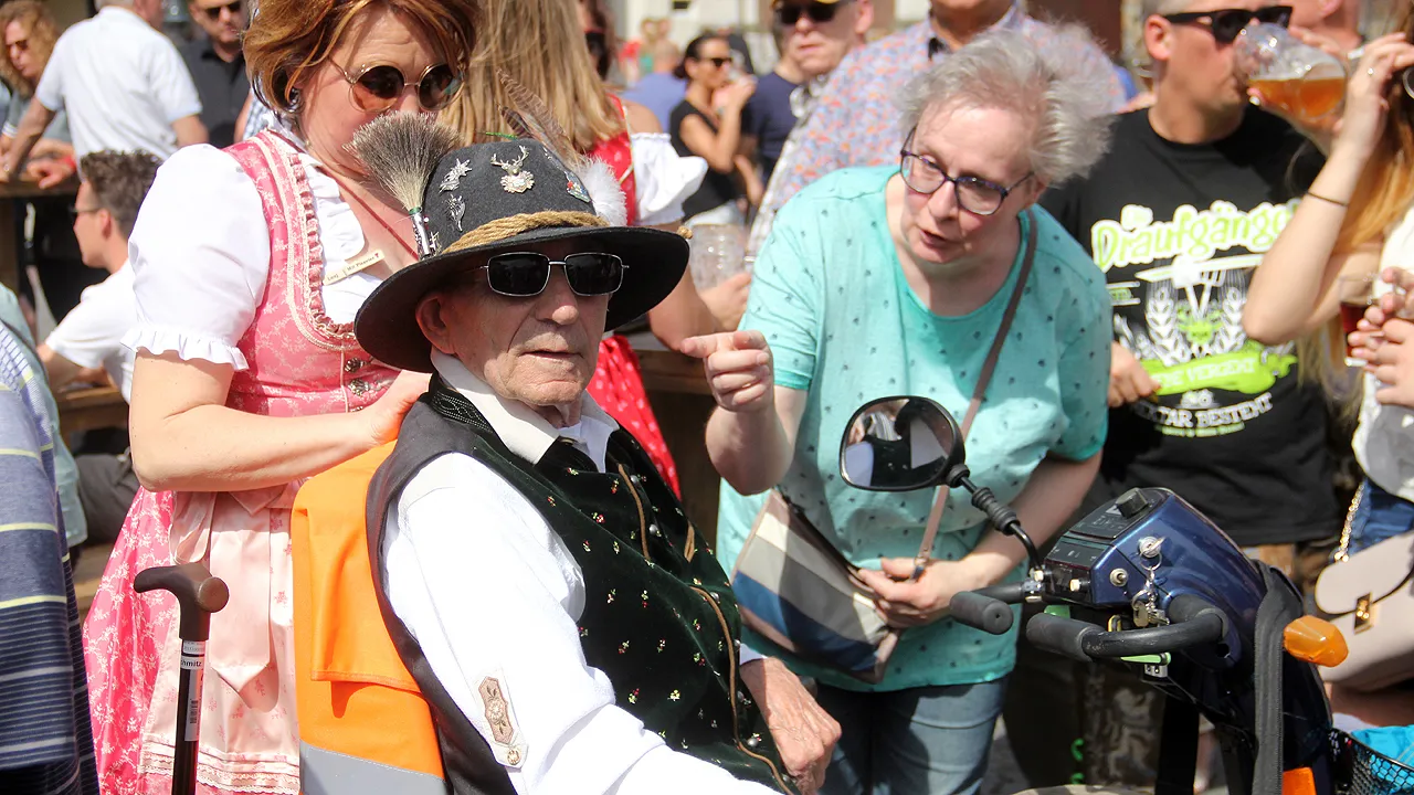 oktoberfeest man in trachten op scootmobiel