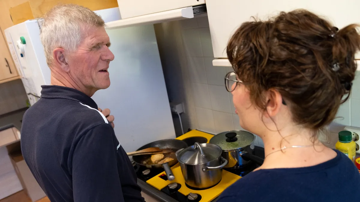 slechtziende man en therapeut koken op aangepaste kookplaat