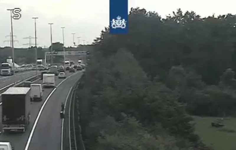 snelwegwandelaar met rolkoffer op vluchtstrook a2 bij born