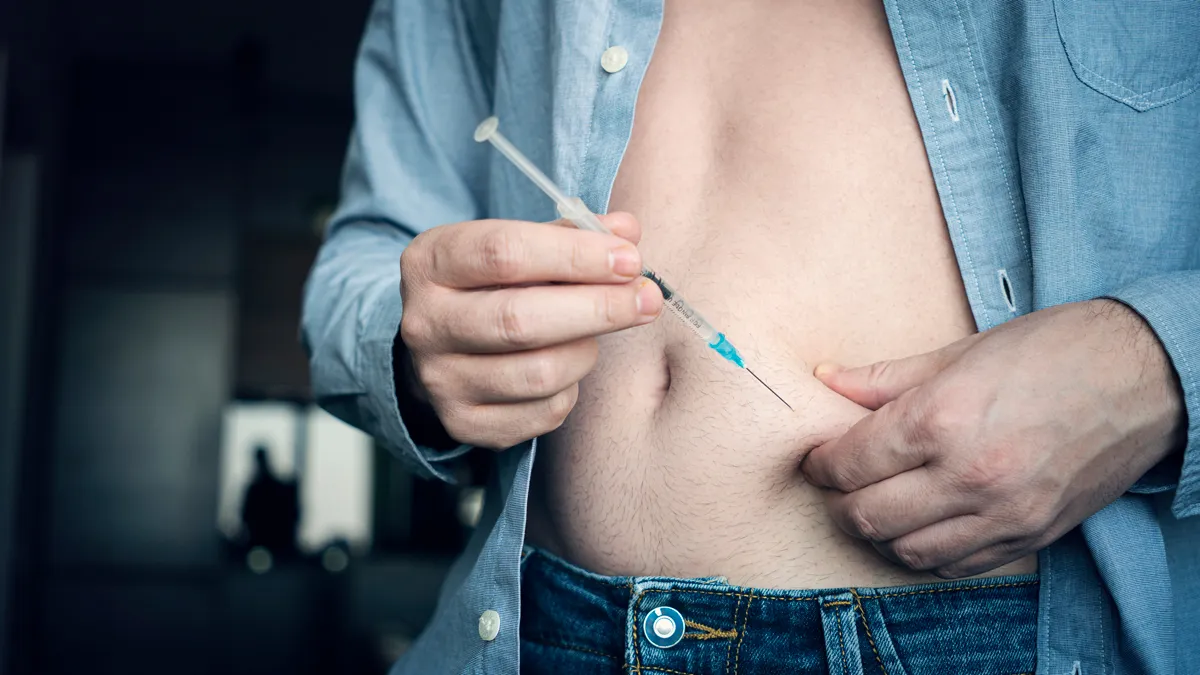 thuis insuline injecteren jonge man hand met behulp van insulinespuit close up zelfmedicatie