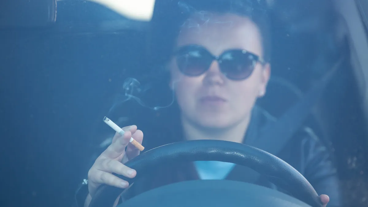vouw rookt achter stuur in auto