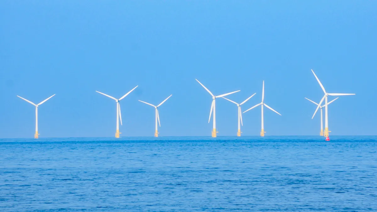 windturbines op zee gezien vanaf het strand