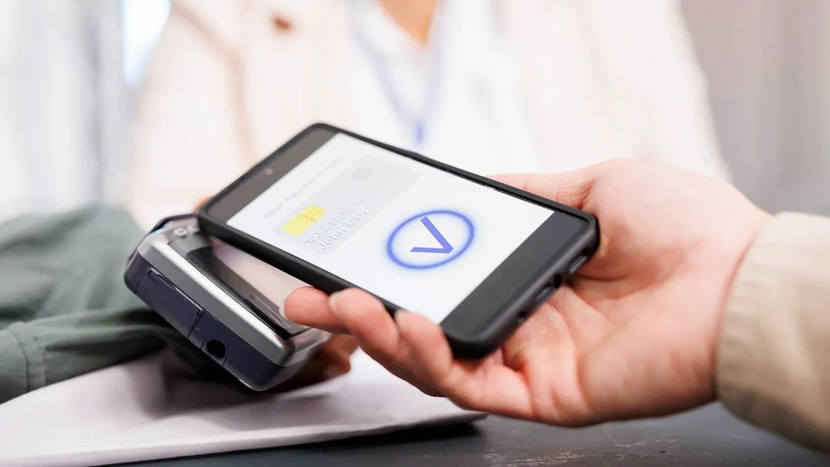 close up customer holding phone using nfc technology pay clothing making digital payment via pos terminal client paying retail store counter desk buying clothes fashion boutique