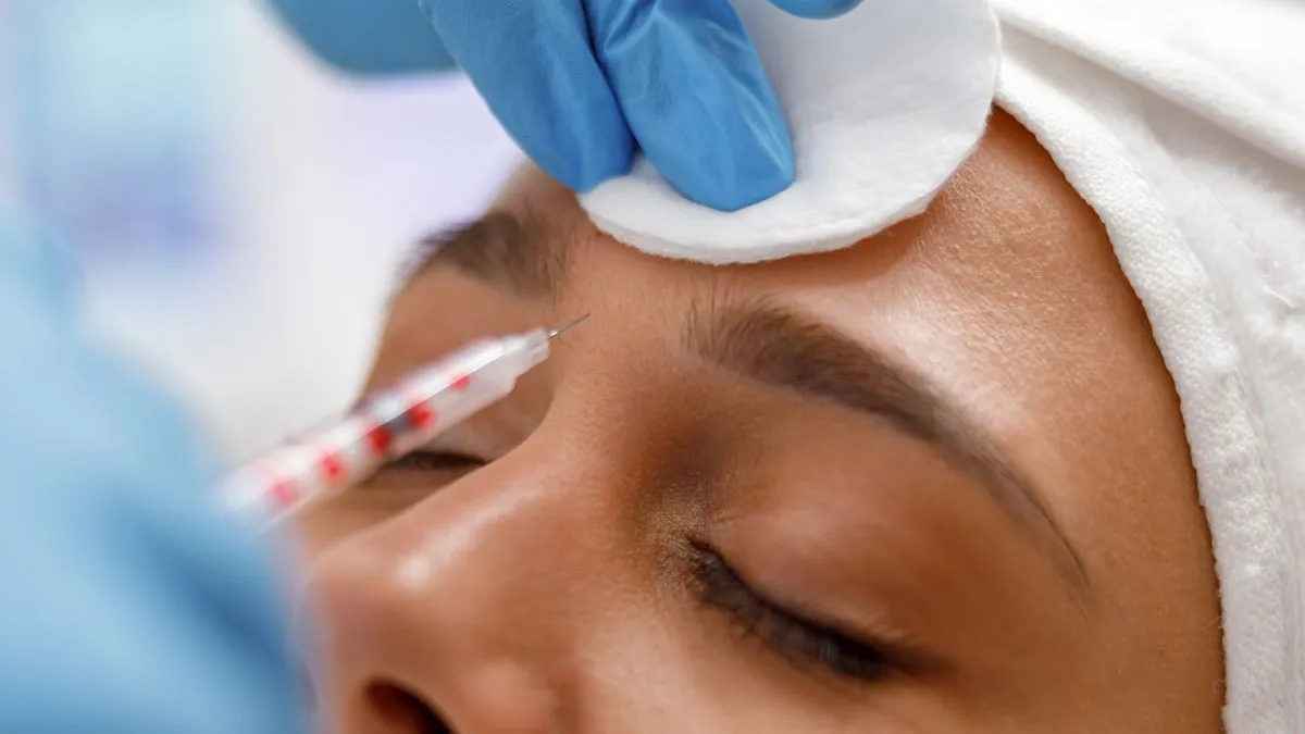 vrouw botox injectiie voorhoofd
