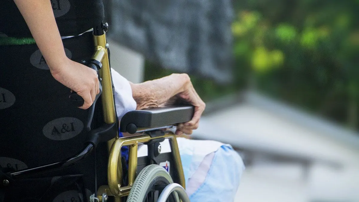mantelzorg persoon duwt rolstoel met zorgvragende