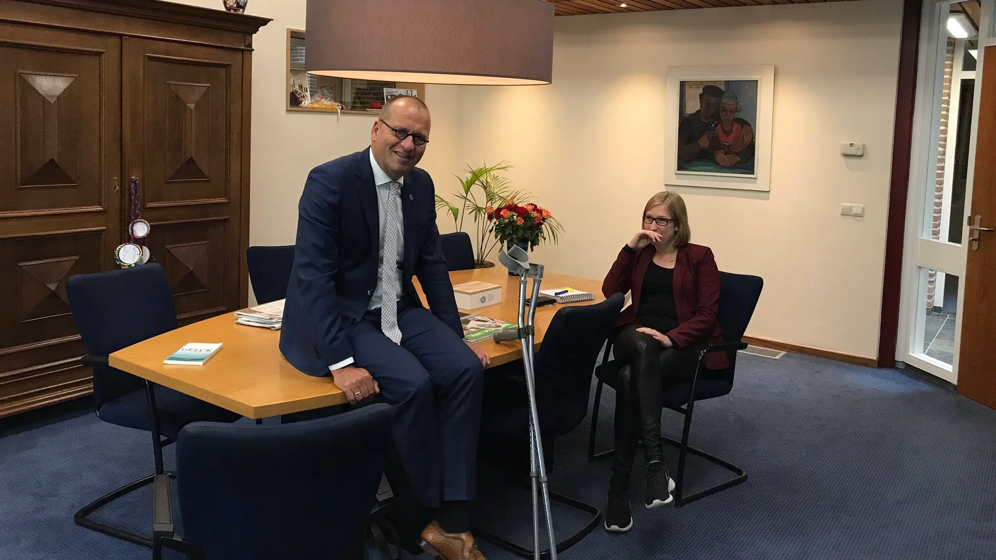 burgemeester blessure dijbeen zittend op tafel krukken e1510590368287