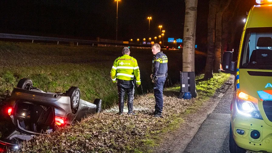 auto op zn kop in sloot a58