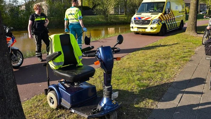 man in scootmobiel te water