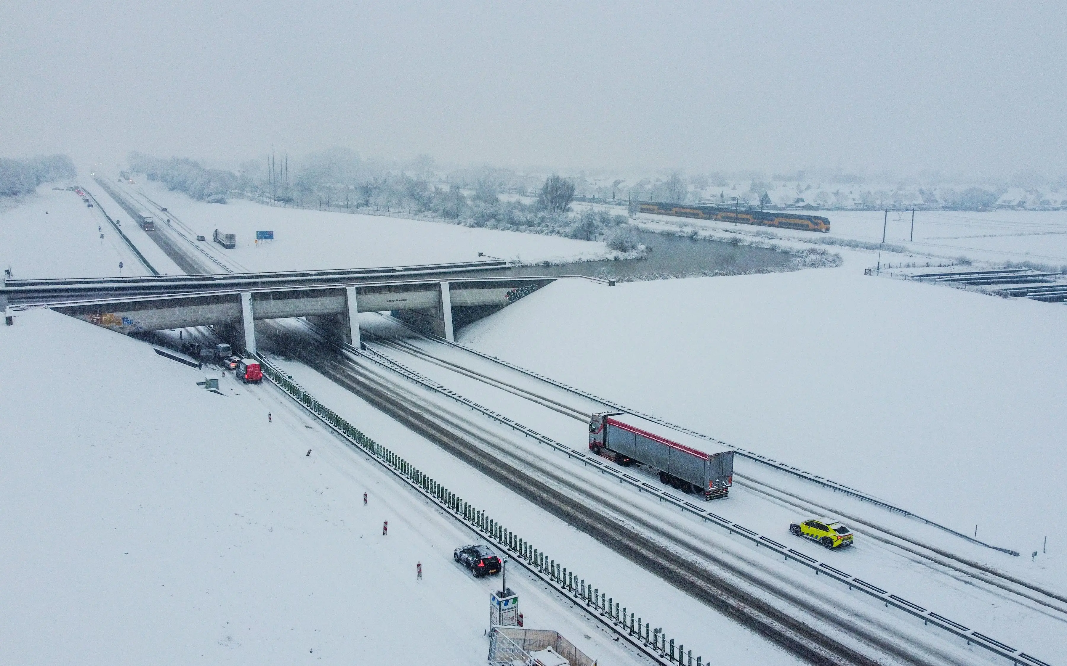 vrachtwagens20rijden20over20een20besneeuwde20friese20snelweg20ondanks20strooien20blijft20lokale20gladheid20mogelijk