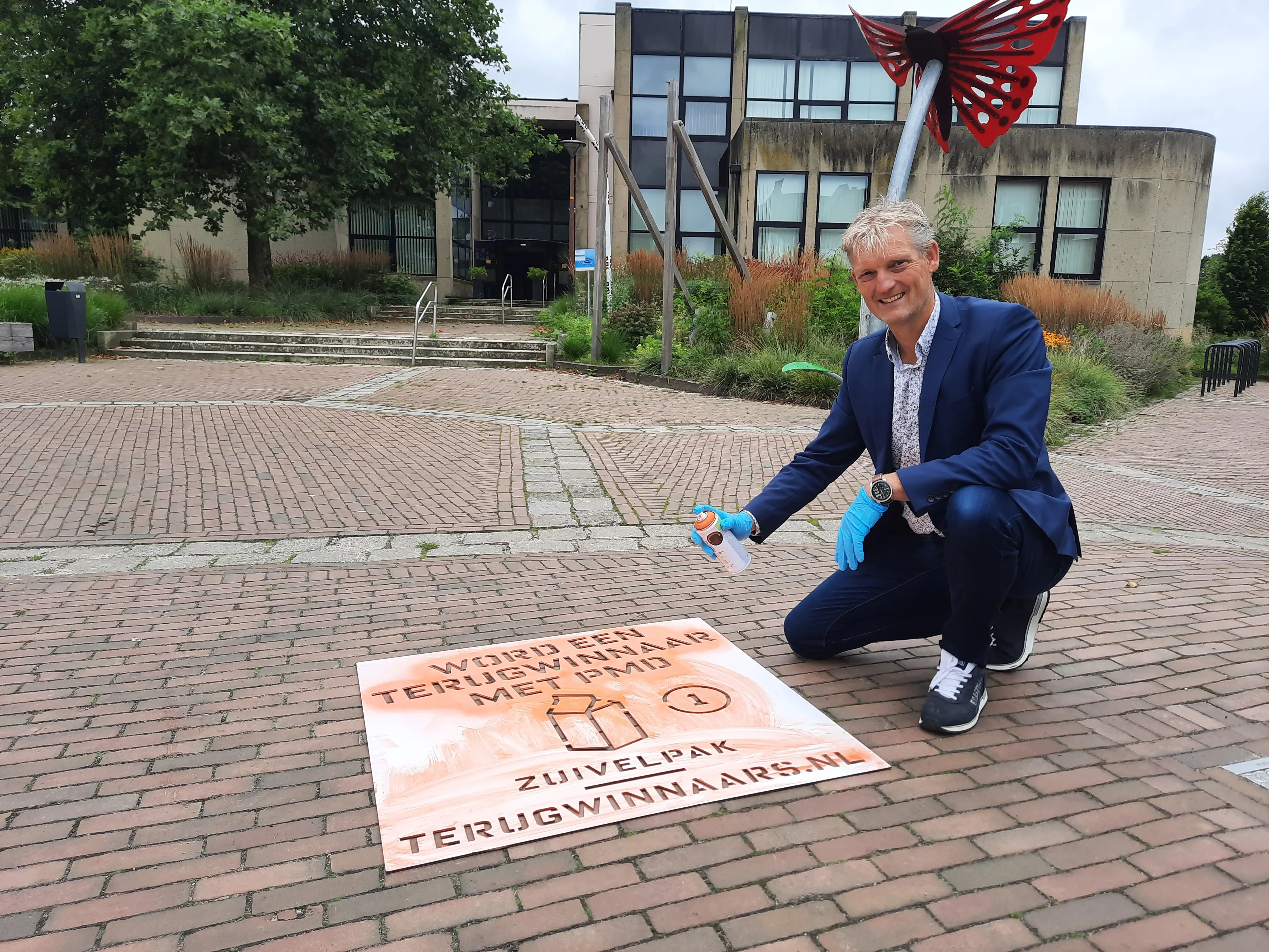 foto wethouder erik volmerink brengt de eerste sjabloon op straat aan