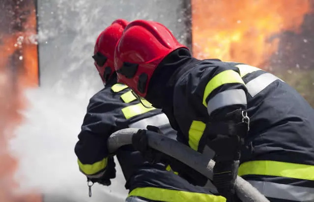 two firemen with a hose