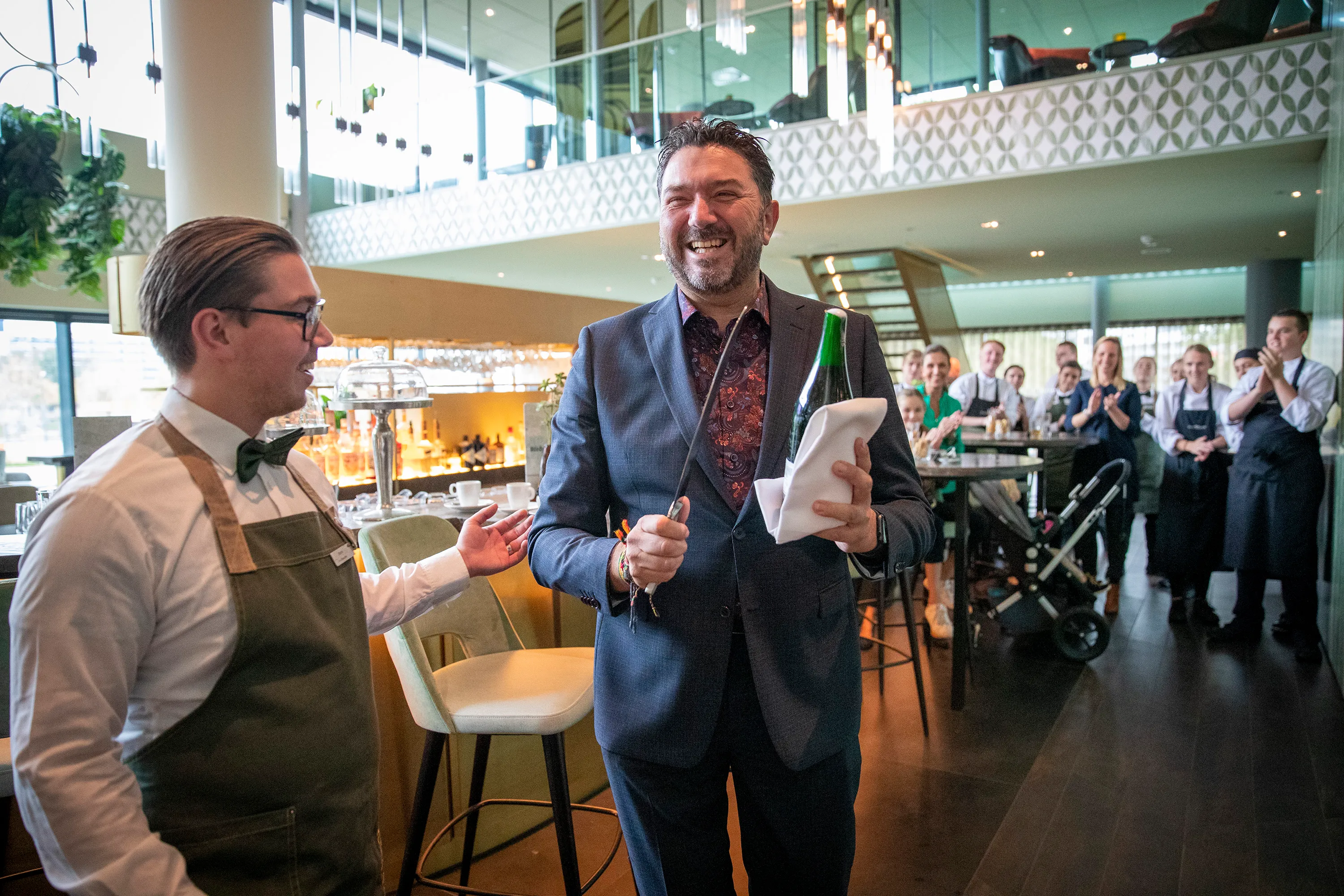 wethouder botter sabreert fles champagne bij de opening schooljaar nova college hotelschool in van der valk hotel haarlem