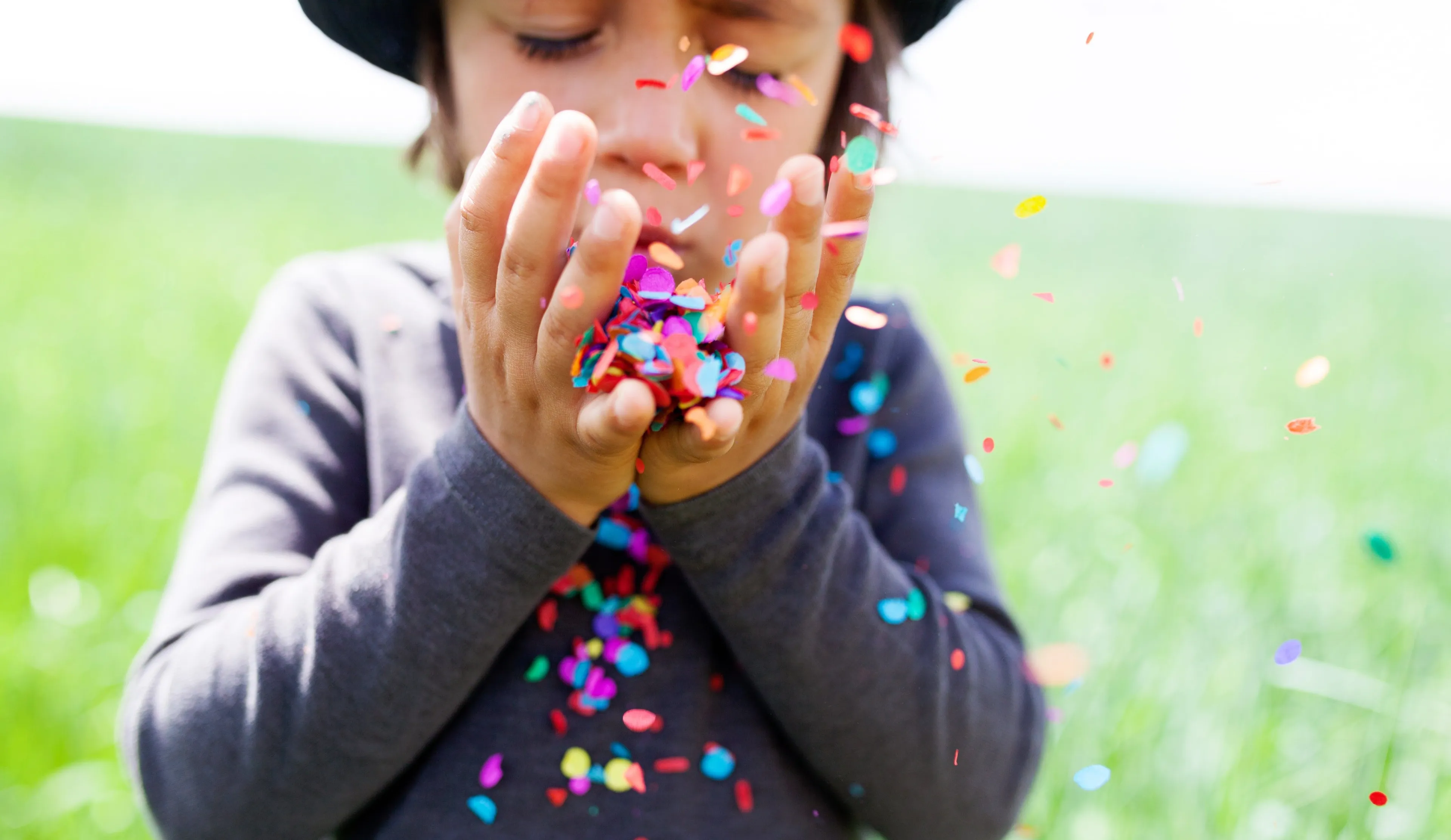 jongetje blaast confetti