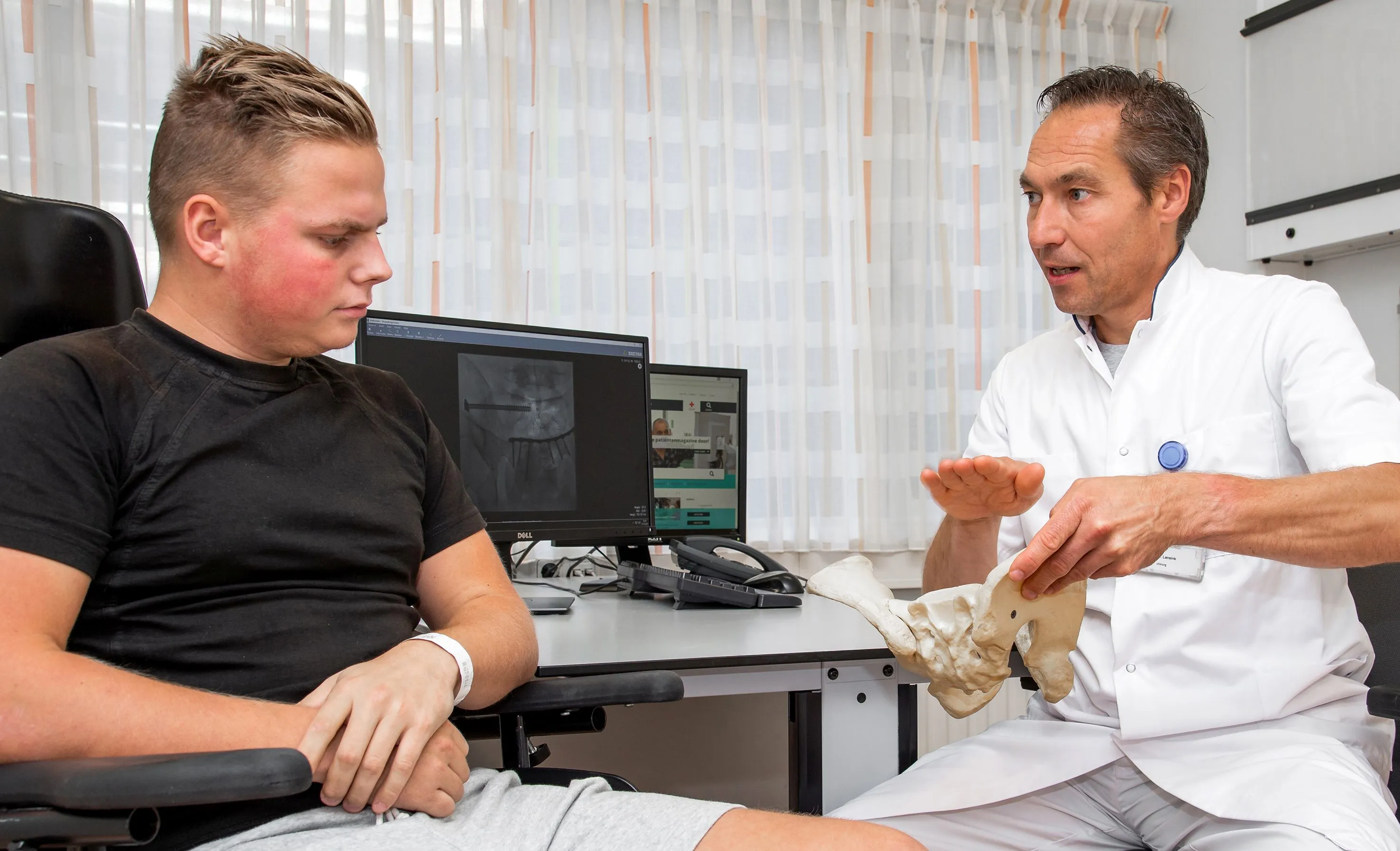 patient in gesprek met traumachirurg lansink
