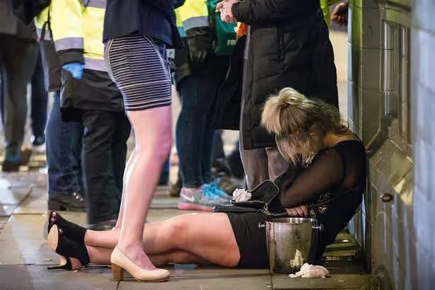 PAY-A-woman-lies-slouched-on-the-pavement-in-Manchester