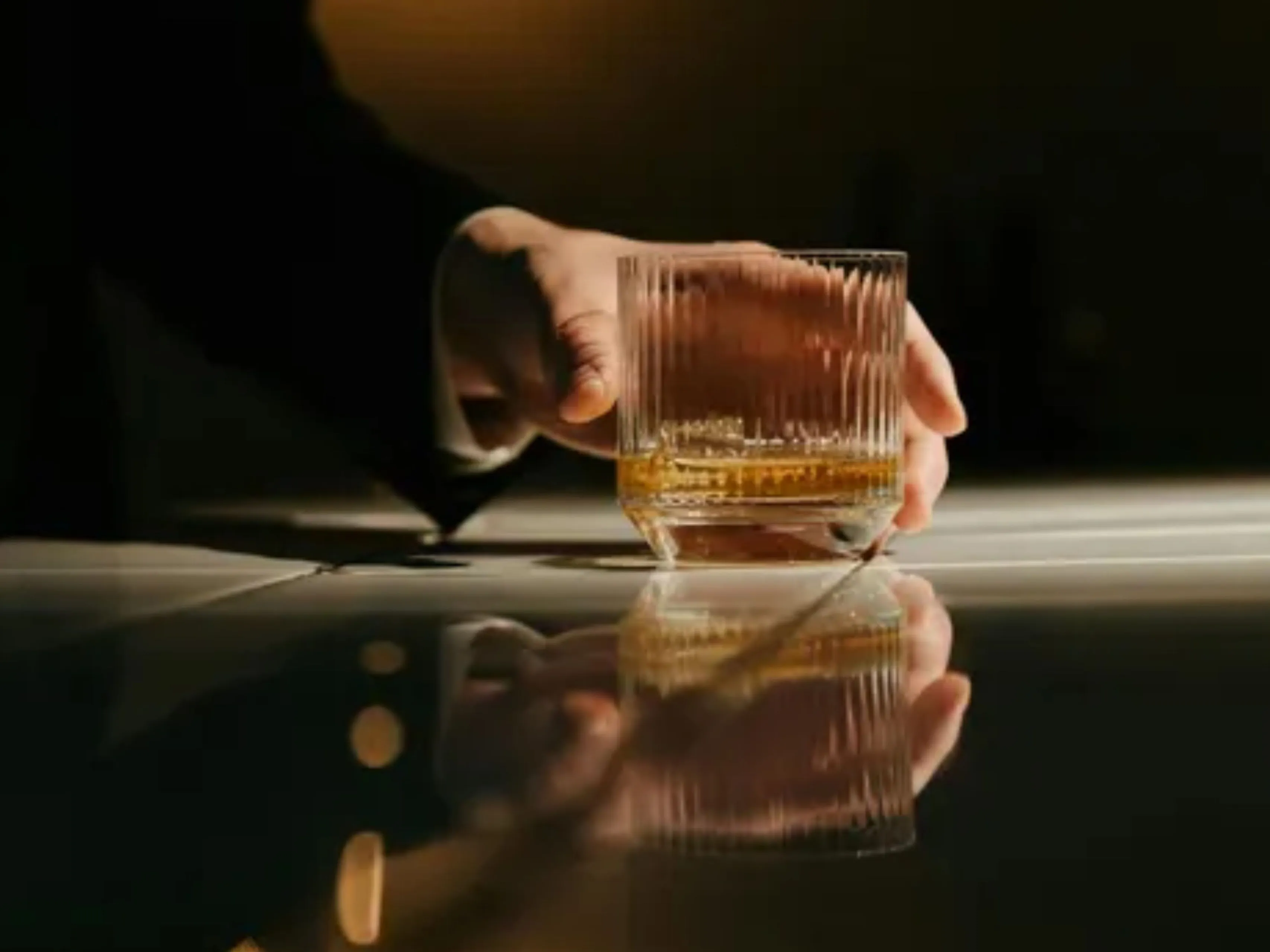 hand met glas whisky