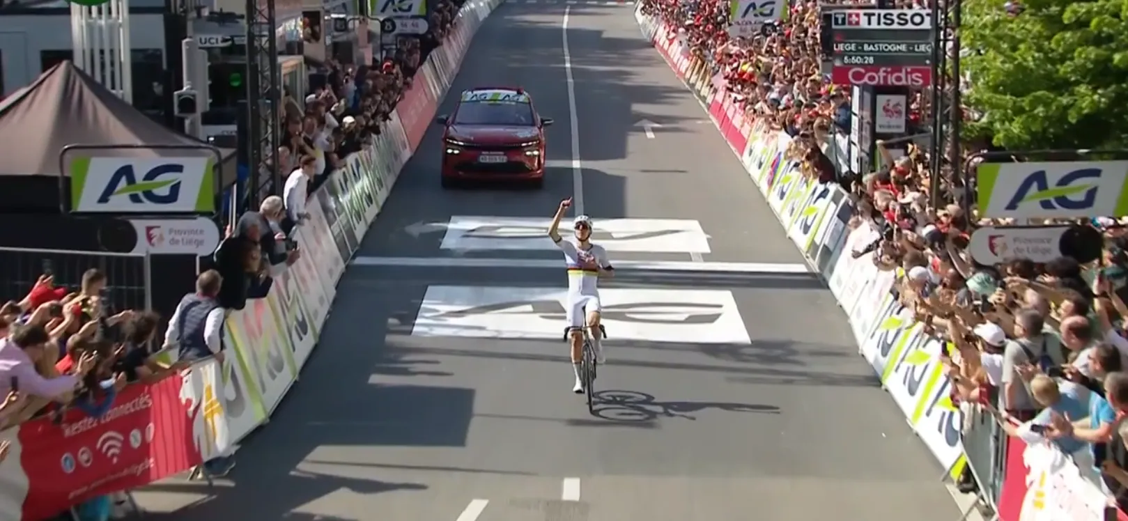 Tadej Pogacar winnend over de finish in Luik