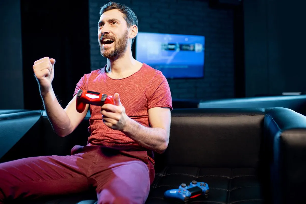 happy man playing video games with gaming console 2023 11 27 05 15 46 utc