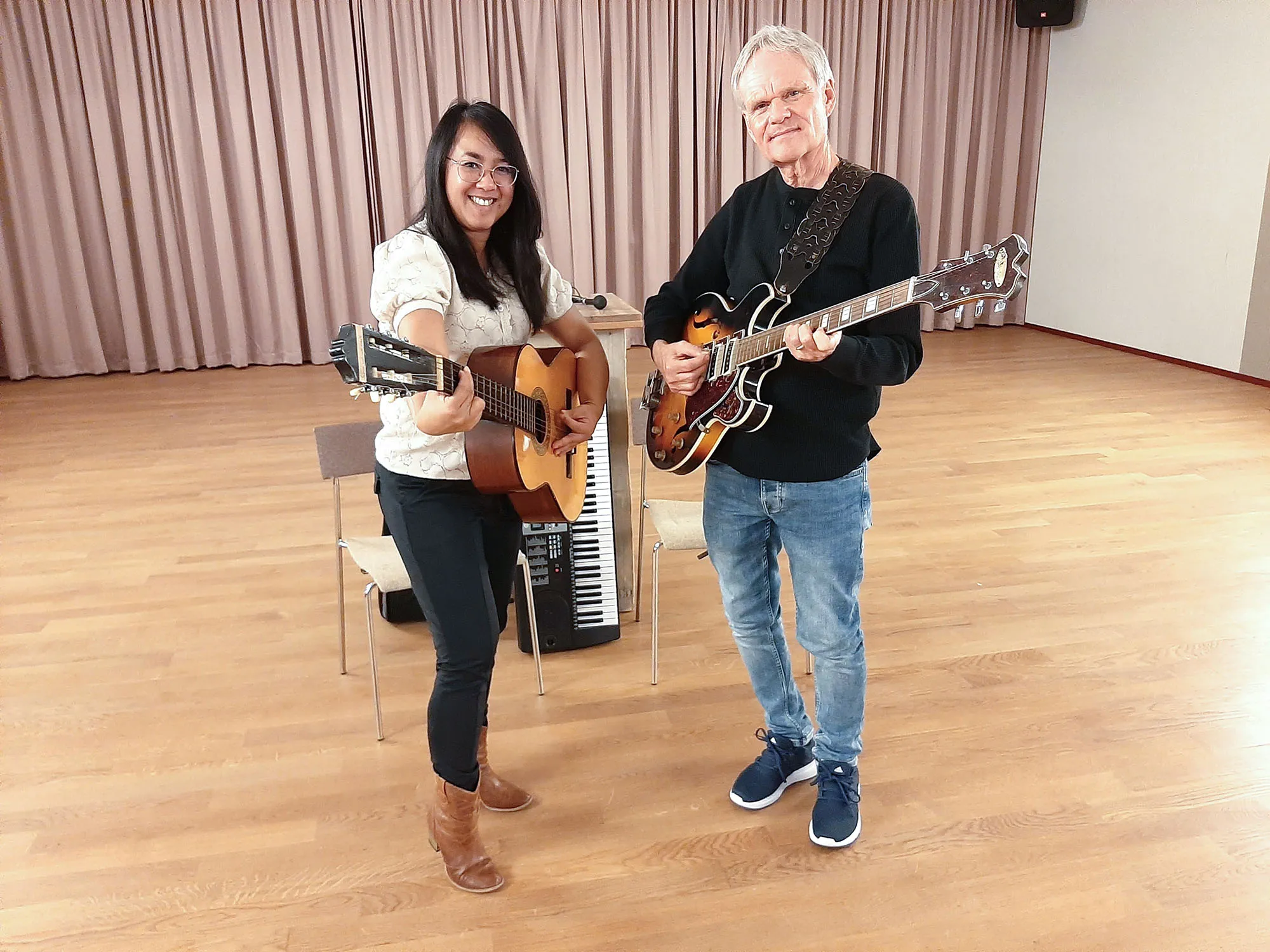 Lenna en Wim staand met gitaren kijken naar de camera