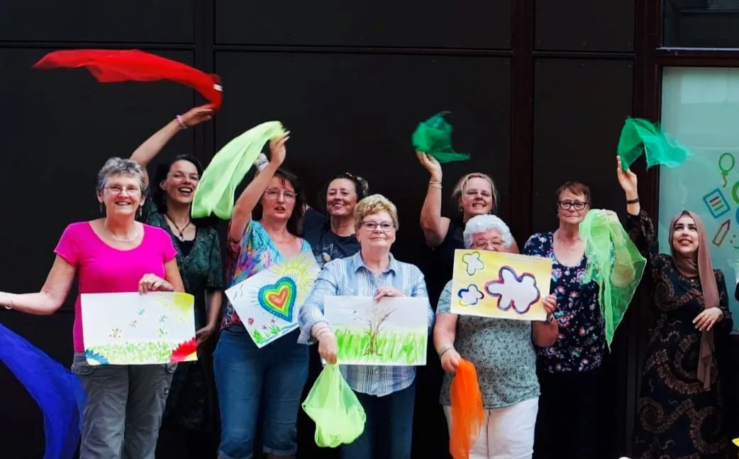 deelnemers van de zomerworkshop zingen en schilderen poseren trots met hun schilderijen foto stichting piezo