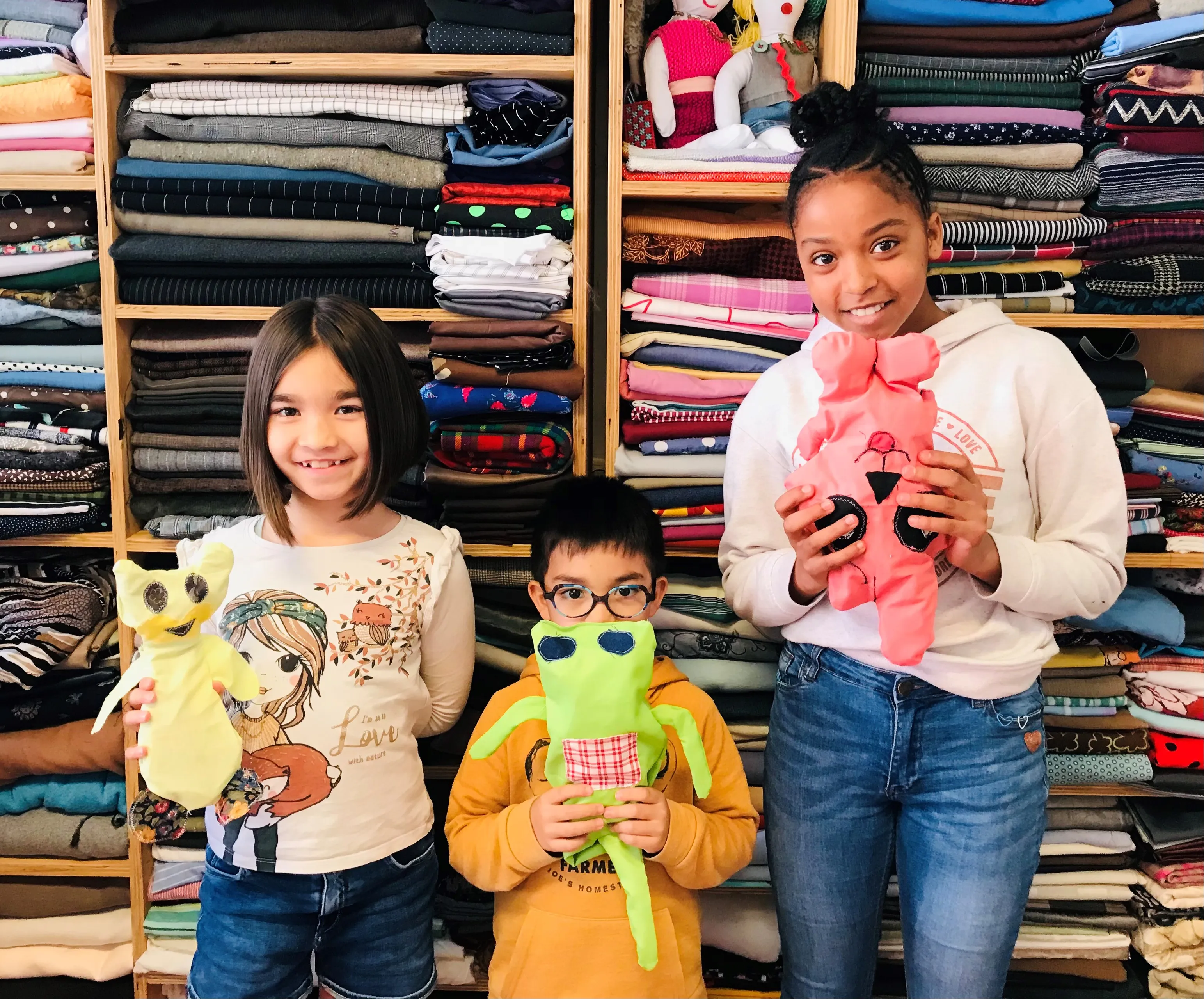 kinderen laten trots hun bij de ambachtenwerkplaats zelf ontworpen en zelfgemaakte knuffel zien fotograaf stichting piezo