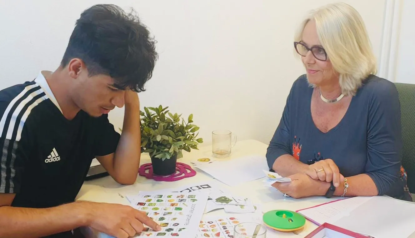 taalcoach marcia en deelnemer nesar zijn bezig met taaloefeningen en taalspelletjes om zo de woordenschat van nesar te vergroten foto 1 fotograaf stichting piezo