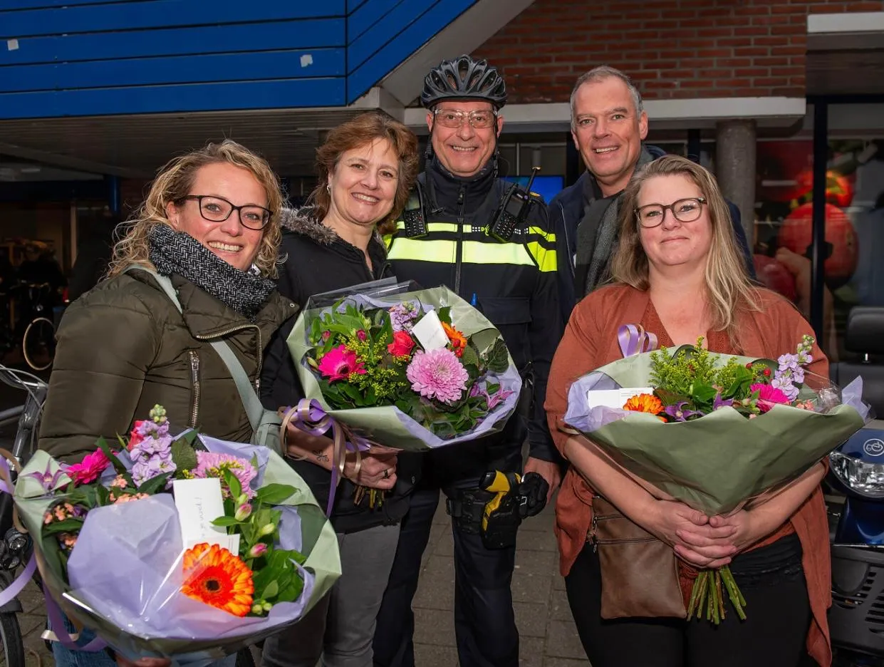 3 vrijwilligers ontvangen bloemen uit handen van wijkwethouder ronald weerwag