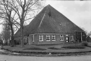 voorgevel van aan water gelegen rietgedekte stopboerderij schuiframen met roedenverdeling erfbeplanting groot schermer 20398848 rce 300x201