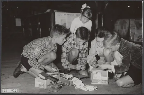 Verzamelen is van alle tijden, zo blijkt uit deze foto, gemaakt in 1957 tijdens de nationale ruilbeursdag van de Nederlandse vereniging ´De Verzamelaar´ in de Koopmansbeurs in Amsterdam Plaatjes sigarenbandjes en suikerzakjes waren zeer in trek (foto: Wikipedia/Nationaal Archief – Joop van Bilsen/Anefo)
