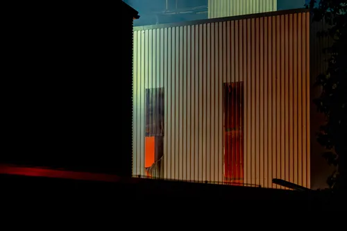 Door een opening in de muur is de rode gloed van het vuur te zien.