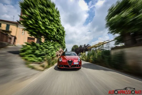 Foto di una Alfa Romeo Giulietta Veloce dinamica, con ripresa dell'anteriore pieno su una strada di campagna.