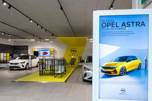 Torino.  Opel ha una lunga tradizione alle spalle, fatta di 160 anni di innovazioni che ha reso accessibili ad una ampia platea di clienti. 160 anni di successi sono stati possibili solo reinventandosi continuamente e anticipando le necessità dei propri clienti.  Il grande rinnovamento di Opel è evidente attraverso i tanti modelli che hanno ricevuto grande apprezzamento dagli esperti e dal pubblico: in primo luogo la nuova Opel Astra, insieme ad Opel Mokka, il veicolo elettrico più venduto nel proprio segmento in Germania e Opel Corsa, che quest’anno ha festeggiato il 40° compleanno. Nei prossimi mesi, Opel offrirà un’esperienza di guida quotidiana ancora più dinamica grazie ai modelli del marchio GSe, reintrodotto di recente. Ampia e varia l’offerta di modelli Opel elettrificati: oggi Opel dispone già di 10 modelli elettrici nella propria gamma in vendita in Italia.  La ridefinizione del marchio tedesco coinvolge il suo posizionamento e cosa Opel vuole rappresentare per i clienti. La sintesi di questa rinascita si sviluppa su 3 concetti principali.  Il primo pilastro del posizionamento è la semplificazione, in inglese detox, intesa come la tendenza alla purezza del design e dell’esperienza di guida e di contatto con Opel.  Il secondo pilastro è l’apertura verso il mondo, l’audacia di essere se stessi e sfidare lo status quo, per una Opel aperta a tutti, inclusiva e accessibile.  Il terzo pilastro è l’innovazione ecologica di cui Opel vuole essere pioniere.  Questi concetti si applicano ai prodotti Opel così come all’interazione tra cliente e marchio, per offrire un’esperienza più pura ed entusiasmante.  Con questo scopo è stata sviluppata un’identità di marca chiara ed audace, che si riscontra in una nuova impostazione del salone, ora realizzata e visibile per la prima volta in Italia presso il salone di Stellantis&amp;You presso via Gattamelata a Milano.  “Sono felice di essere qui per vivere un momento importante per il marchio Opel: a Milano, nella sede di Stellantis&amp;You, oggi apre ufficialmente al pubblico il primo showroom Opel d’Italia con la nuova identità di marca. Si tratta del sito pilota che anticipa il rinnovamento di tutta la rete che si svilupperà durante il 2023” dichiara Federico Scopelliti, Direttore del Brand Opel in Italia.  Con il nuovo Showroom, Opel compie un nuovo passo significativo verso il nuovo corso: dopo il rinnovamento della gamma e la nuova immagine di marca ora interviene sulla esperienza di acquisto del cliente, che troverà un ambiente moderno e accattivante.  All’esterno le vetrate trasparenti invitano i clienti a entrare ed esplorare gli spazi.  La nuova struttura del salone presenta un notevole impatto visivo, l’ambiente è luminoso. Il protagonista è lo slash giallo, la firma di Opel, che rende lo showroom caldo e pieno d’energia e con un netto richiamo all'elettrificazione del marchio.  Lo stile del design è moderno e accattivante in tutti gli elementi di arredo. La prima zona che accoglie il cliente è un tavolo esperienziale che sostituisce il tradizionale ricevimento e può essere utilizzato come punto di scambio tra cliente e venditore o come area di attesa, dove il cliente ha la possibilità di fare un viaggio virtuale nei 160 anni di storia di Opel. Attraverso un QR code il cliente può visitare il garage virtuale e navigare tra i vari modelli Opel in vendita e approfondire gli aspetti di suo interesse prima di ricevere la consulenza di uno specialista.  Le aree di vendita si distinguono dal resto del salone con dei colori più caldi per creare un'atmosfera riservata e accogliente al fine di mettere il cliente a suo agio nella gestione dell’acquisto. Trova spazio, inoltre, uno spazio interamente dedicato al mondo elettrico ed ai suoi servizi, ciò che è il pilastro portante della strategia di Opel.  All'interno del salone ci sono numerosi touchpoint digitali con schermi di ultima generazione, integrati nell’arredamento. Vi si trovano video wall, totem e il configuratore per gli ultimi modelli Opel in vendita.  nuovi showroom opel 2023