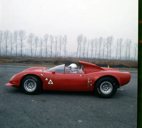 Immagine della Alfa Romeo 33/2 Periscopica di colore rosso su una strada con alberi sullo sfondo e nebbia