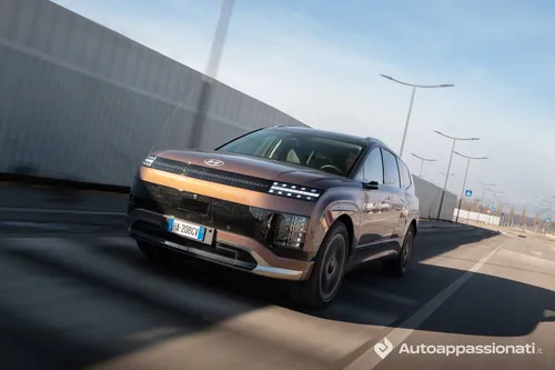 Vista anteriore della Hyundai Ioniq 9color bronzo in movimento su una strada asfaltata