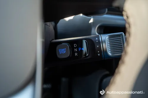 Dettaglio del selettore del cambio della Hyundai Ioniq 9 posizionato dietro il volante, con i pulsanti per 'START STOP', 'D' (Drive), 'N' (Neutral), 'R' (Reverse) e 'P' (Park).